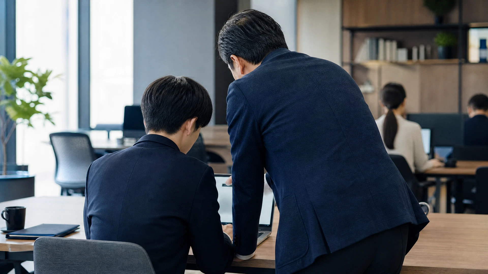 会議室で研修を受ける若手社員たちとスクリーンに映るAI活用画面